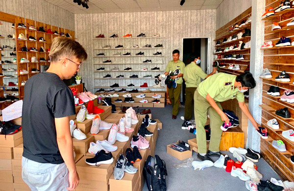 Lực lượng quản lý thị trường kiểm tra cơ sở kinh doanh giày. Ảnh: A.H