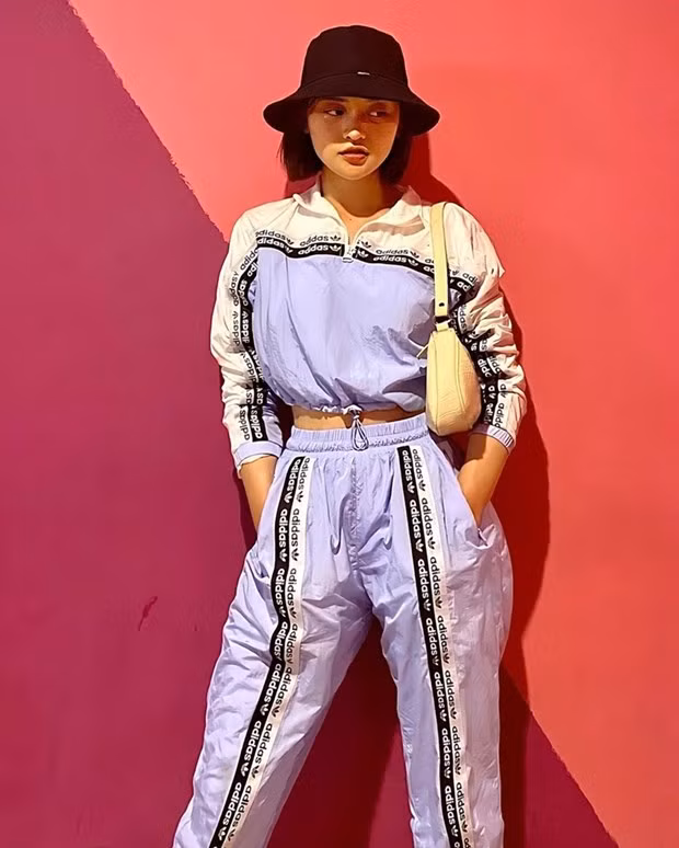 Bộ đồ thể thao của adidas được Thùy Anh kết hợp phá cách với túi quai ngắn và mũ bucket, tôn vẻ năng động, phóng khoáng.