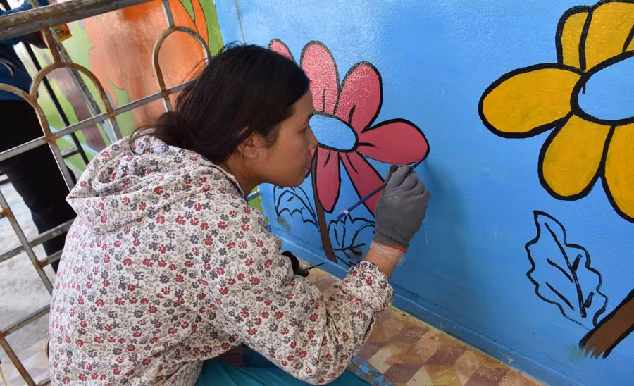 Những họa sỹ không chuyên tạo thêm vẻ đẹp thân thiện cho ngôi trường. Ảnh: Hà Phương