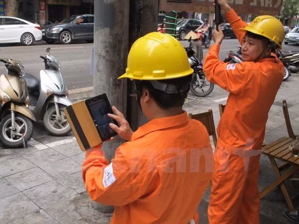 Nhân viên ngành điện ghi chỉ số côngtơ của khách hàng. (Nguồn: Đức Duy/Vietnam+)