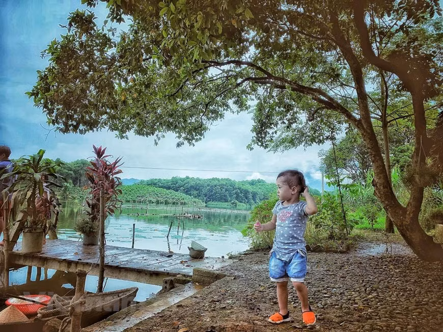 Với trẻ em thành thị, đứng giữa sông nước mây trời trong lành như này là cảm giác vô cùng lạ lẫm và thú vị. (Ảnh: Xuân Mai/Vietnam+)