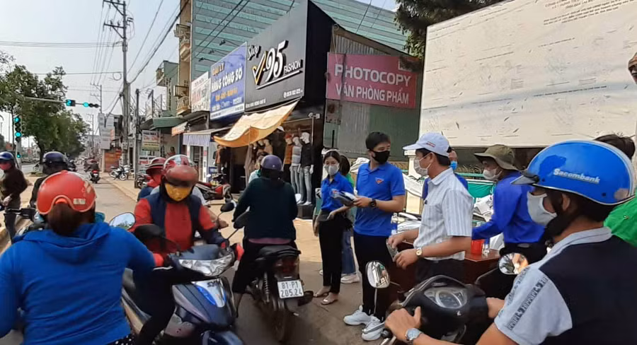 Các tình nguyện viên và lãnh đạo thị trấn Chư Sê tham gia phát khẩu trang tại cổng UBND thị trấn. Ảnh: Hoàng Viên 