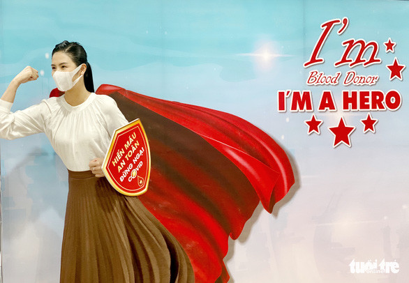  Sau khi hiến máu, hoa hậu Ngọc Hân còn năng động check in với poster cổ động - Ảnh: MAI THƯƠNG