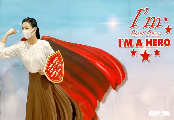  Sau khi hiến máu, hoa hậu Ngọc Hân còn năng động check in với poster cổ động - Ảnh: MAI THƯƠNG