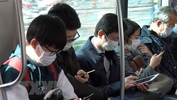  Người dân đeo khẩu trang phòng tránh lây nhiễm dịch COVID-19 tại Tokyo, Nhật Bản. (Ảnh: THX/TTXVN)