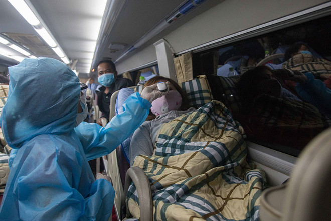 Bác sĩ Bùi Thị Thanh Hải (trước), Trưởng trạm y tế P.5 (Q.11), đi phun thuốc khử khuẩn khu vực có ca bệnh - Ảnh: CTV