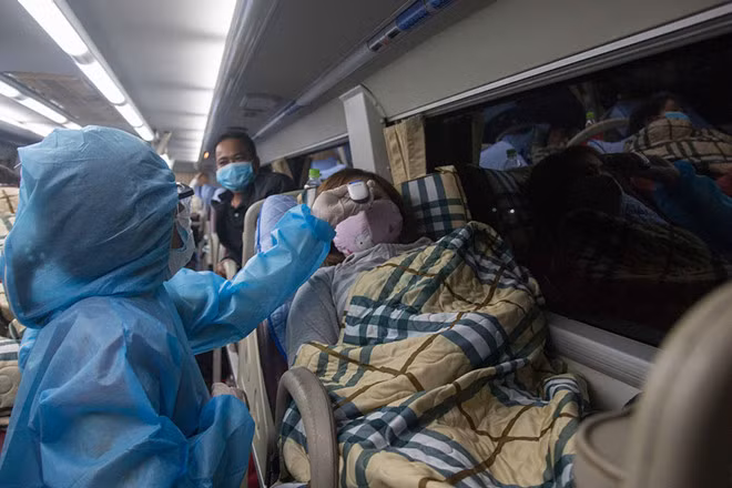 Bác sĩ Bùi Thị Thanh Hải (trước), Trưởng trạm y tế P.5 (Q.11), đi phun thuốc khử khuẩn khu vực có ca bệnh - Ảnh: CTV