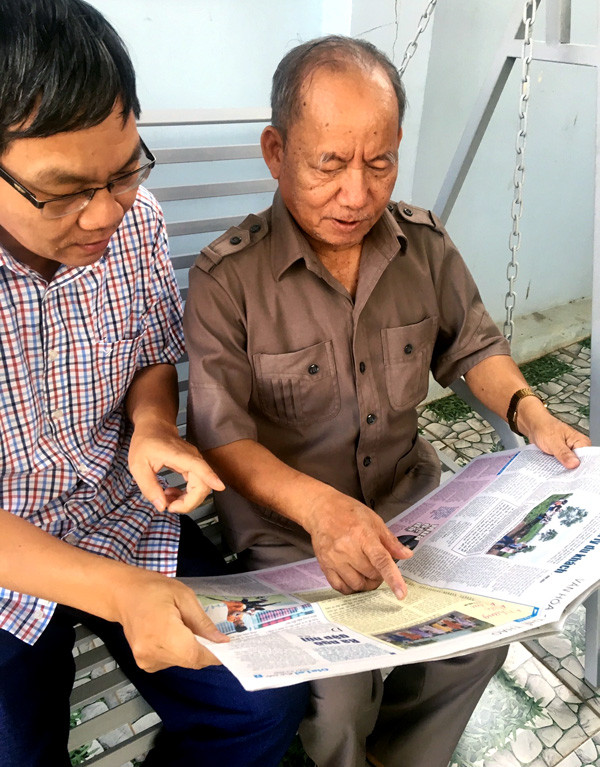 Ông Ka Ba Tơ (bìa phải) đang xem ấn phẩm Báo Gia Lai mới nhất. Ảnh: N.C