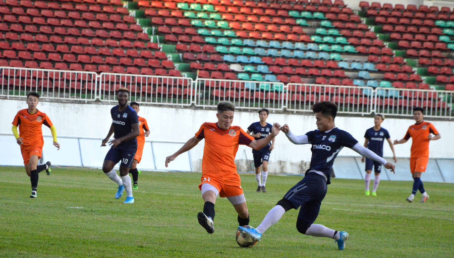 Cầu thủ HA.GL (áo xanh đậm) tranh chấp bóng với Công an Nhân dân (áo cam). Ảnh: Minh Vỹ
