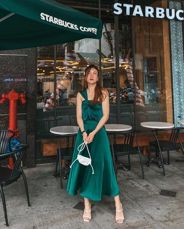 Yến Nhi chứng tỏ gu thời trang sành sỏi với bộ đôi áo váy tiệp màu xanh ngọc lục bảo. Cặp phụ kiện sandals và túi xách cùng tông trắng điểm xuyết nét duyên dáng cho nữ ca sỹ.