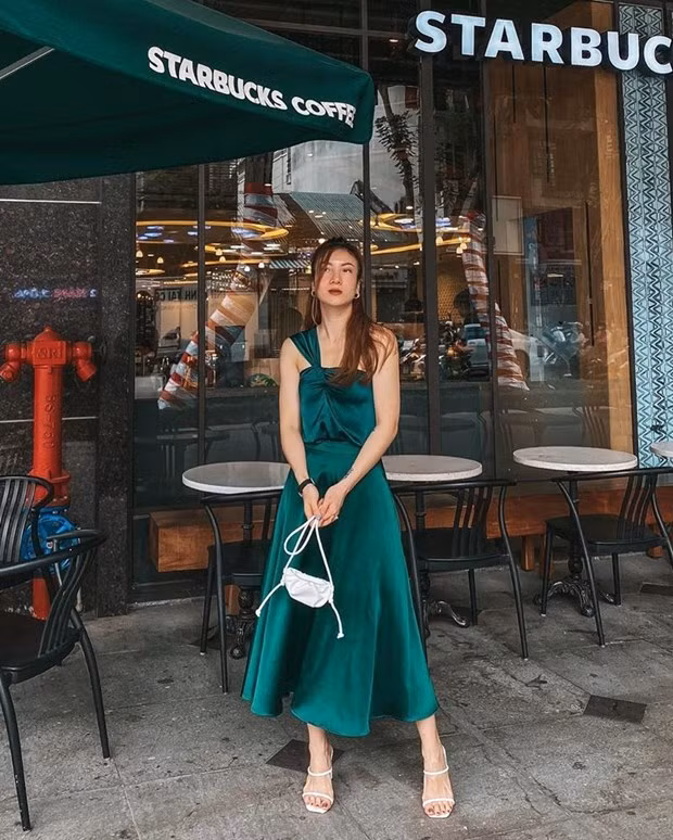 Yến Nhi chứng tỏ gu thời trang sành sỏi với bộ đôi áo váy tiệp màu xanh ngọc lục bảo. Cặp phụ kiện sandals và túi xách cùng tông trắng điểm xuyết nét duyên dáng cho nữ ca sỹ.