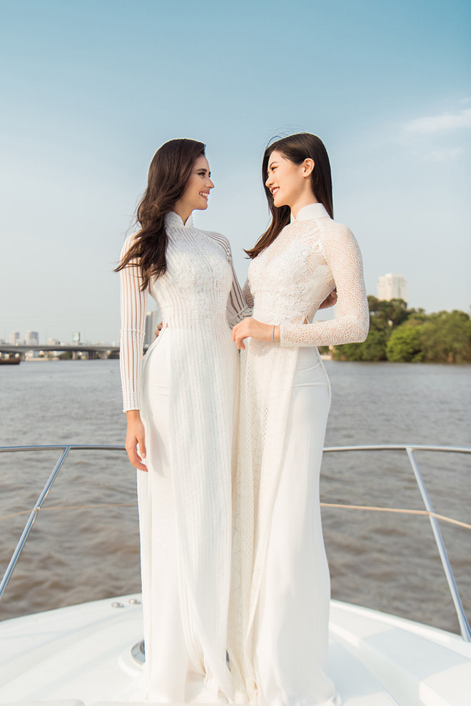Vũ Hương Giang cũng mặc một thiết kế áo dài trắng ren khá đồng điệu với đương kim Miss Supranational, hai người đẹp giống như cặp chị em quyến rũ