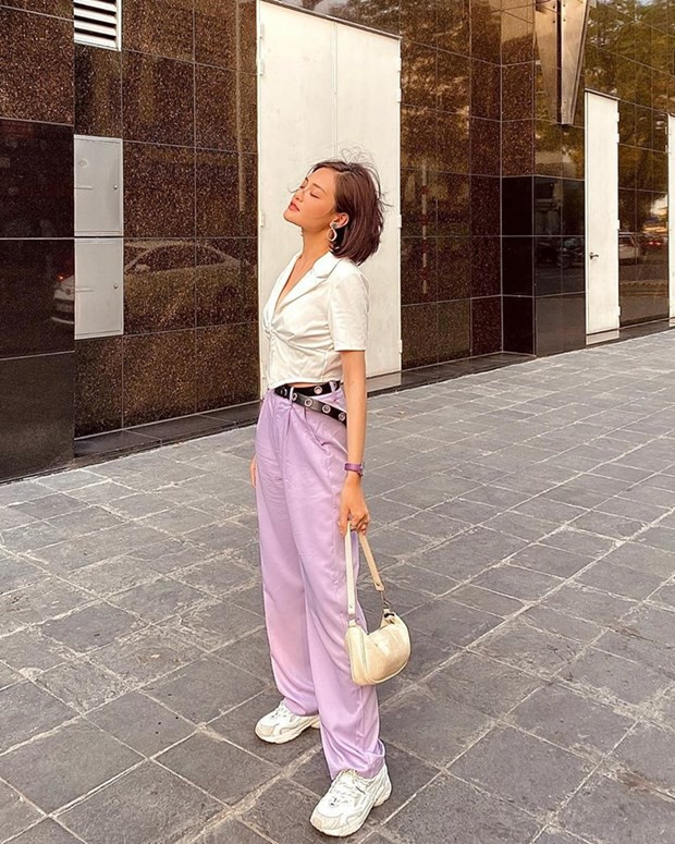 Thùy Anh nổi bật với bộ đôi crop top dáng sơ mi và quần Hip Hop tím phấn. Túi xách quai ngắn ''hot hit'' cũng được trưng dụng cùng với sneakers, giúp set đồ dạo phố thêm hấp dẫn.
