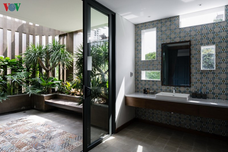 Phòng vệ sinh kế bên ban công có cây xanh. Ánh sáng tự nhiên chan hòa.