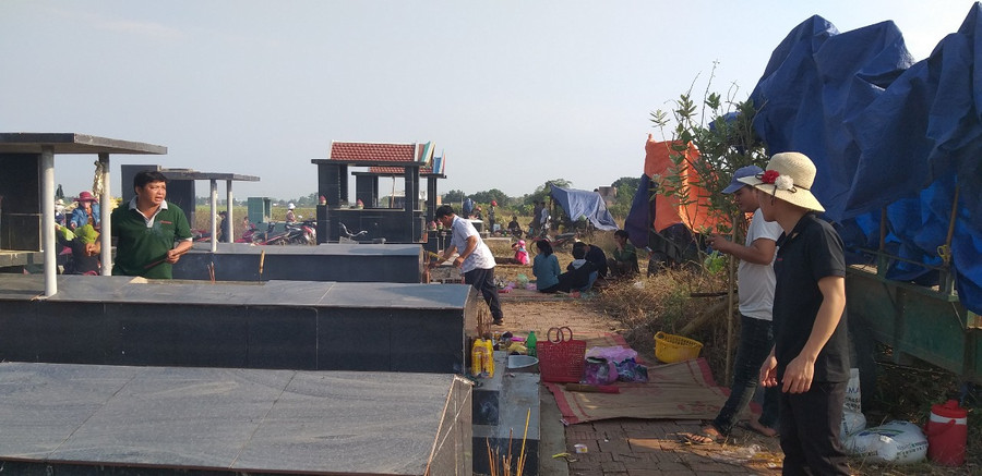  Con cháu thắp nhang xin phép dọn dẹp phần mộ ông bà, tổ tiên. Ảnh: Vũ Chi