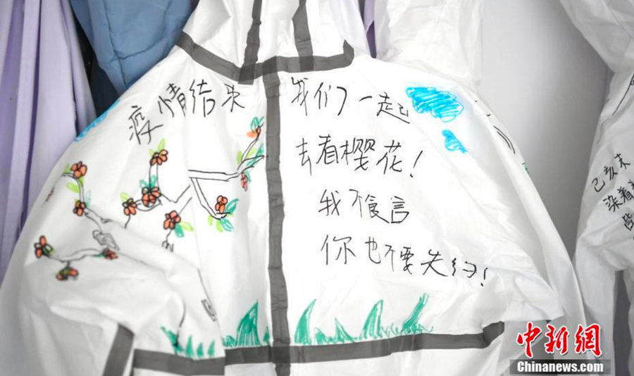 Trần Tư Mẫn, một y tá tại Bệnh viện số 6 Vũ Hán, vẽ hình ảnh hoa anh đào lên trang phục bảo hộ - Ảnh: Chinanews