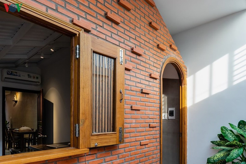 Phía bên trong sau khoảng để xe là một bức tường xây gạch không trát rất tỉ mỉ đem lại vẻ đẹp thô mộc và duyên dáng. Lối vào trong nhà là một ô cửa nhỏ cuốn vòm.