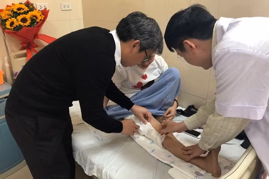 Các bác sĩ kiểm tra chân cho bệnh nhân sau ca phẫu thuật.