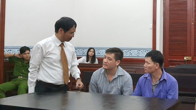 Luật sư trao đổi với bị cáo tại phiên tòa. Ảnh: HUYỀN MAI