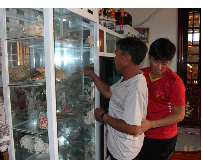 Ngư dân Nguyễn Việt cùng con trai bên tủ đựng kỷ vật Hoàng Sa