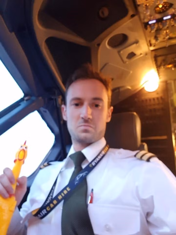 Hình ảnh từ video cho thấy phi công đang nắm cổ, nghịch một con gà cao su. Ảnh: The Sun.