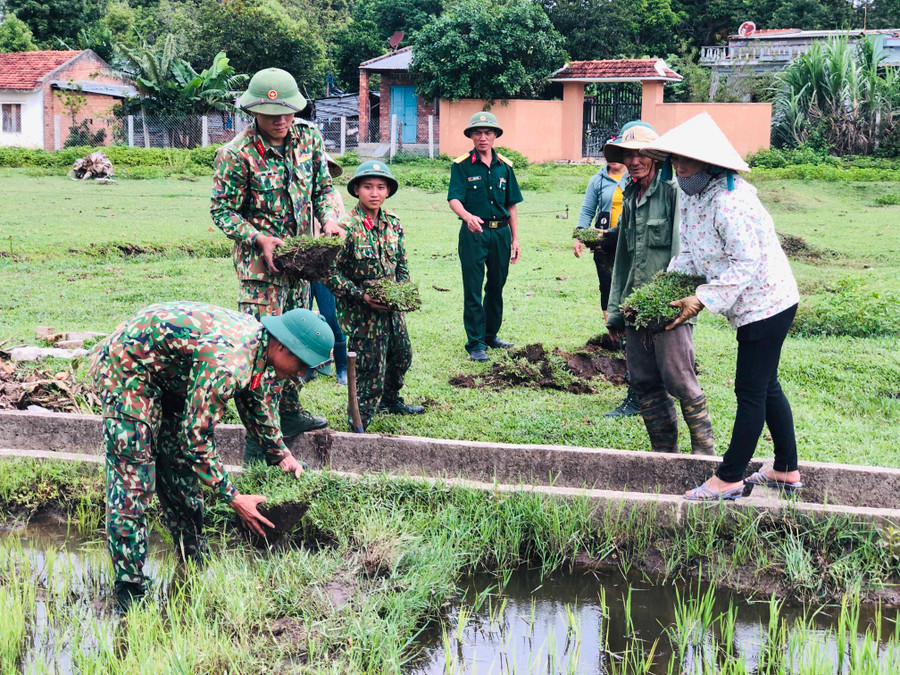 Cán bộ, chiến sĩ Lữ đoàn Pháo binh 40 (Quân đoàn 3) giúp người dân khơi thông kênh mương nội đồng. Ảnh: THỦY BÌNH