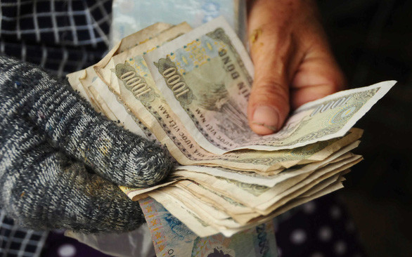 Mớ tiền lẻ mà những người bồng heo thuê kiếm được trong một buổi sáng. Ảnh: B.D.