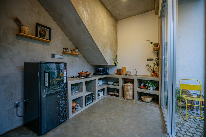 Bếp nấu đặt ngay dưới chân cầu thang. Cửa trượt bằng kính để người nội trợ có thể nấu nướng nhưng vẫn quan sát được khoảng vườn bên ngoài, hay hình ảnh các con đang chơi đùa.