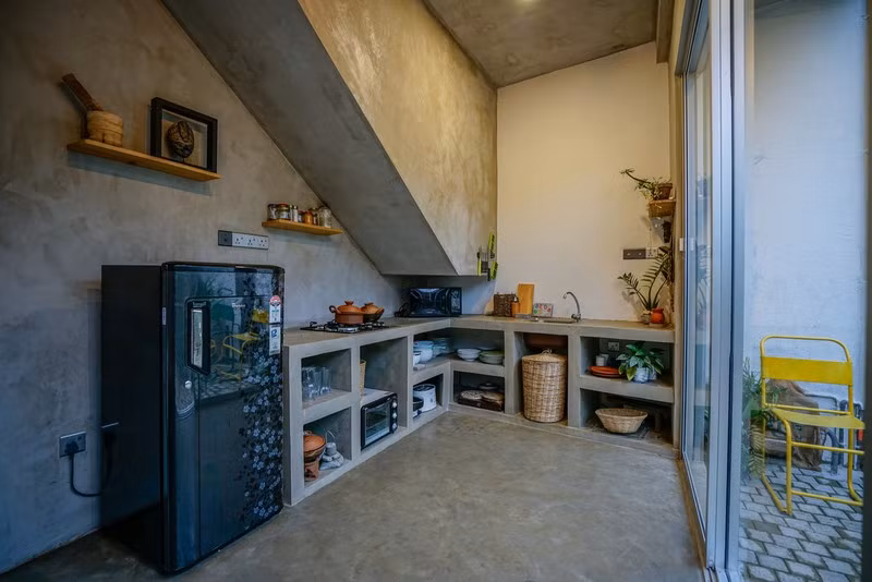 Bếp nấu đặt ngay dưới chân cầu thang. Cửa trượt bằng kính để người nội trợ có thể nấu nướng nhưng vẫn quan sát được khoảng vườn bên ngoài, hay hình ảnh các con đang chơi đùa.