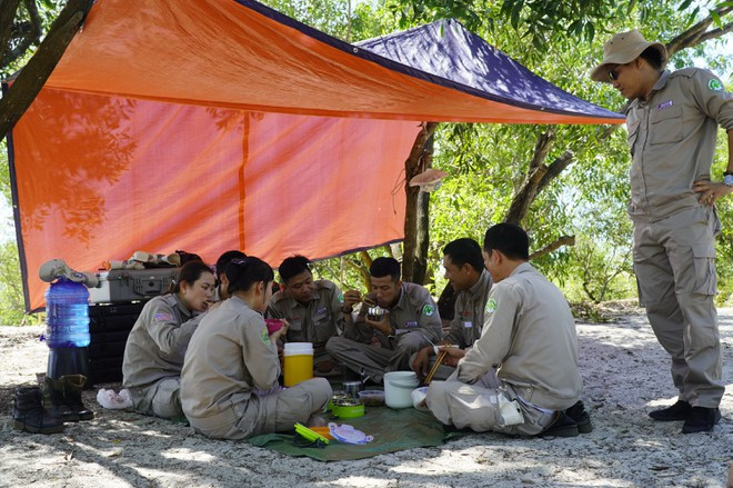 Bữa cơm chóng vánh giữa hiện trường rà phá của những nhân viên dự án Renew/NPA ẢNH: NGUYỄN PHÚC