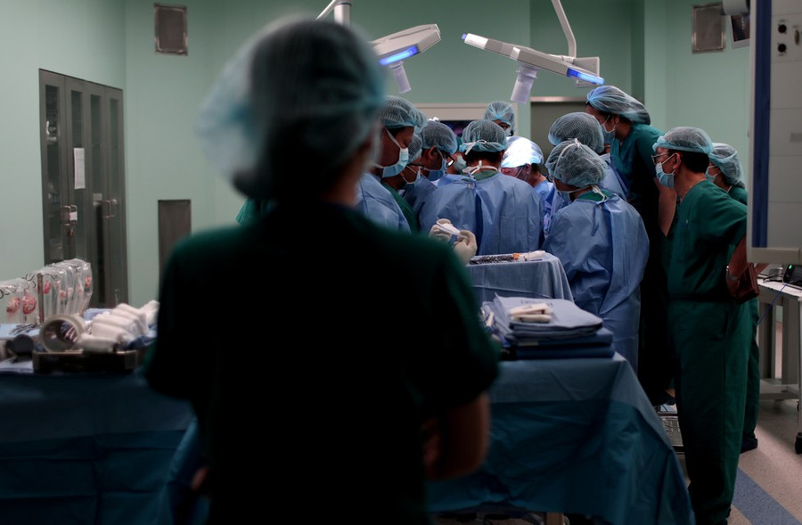 Hình ảnh các bác sĩ tiến hành phẫu thuật cho 2 bé, bên ngoài nhiều y bác sĩ đứng chờ đợi mong chờ ca phẫu thuật diễn ra tốt đẹp nhất có thể ẢNH: NGỌC DƯƠNG