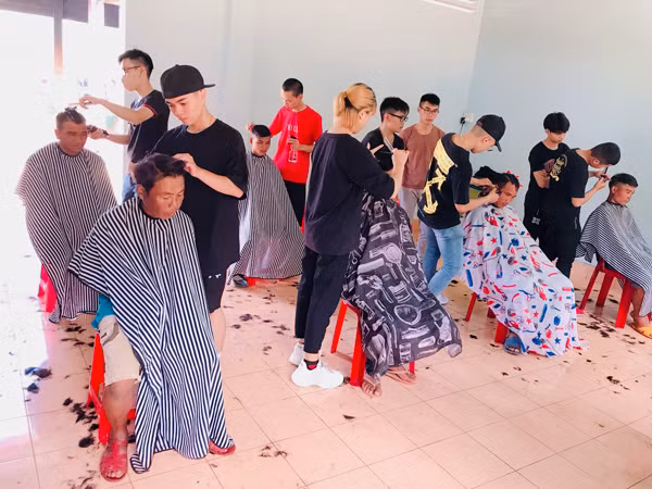 Nhân viên Barbershop Gia Lai cắt tóc cho bệnh nhân điều trị tại Bệnh viện Đa khoa tỉnh. Ảnh: Thủy Bình