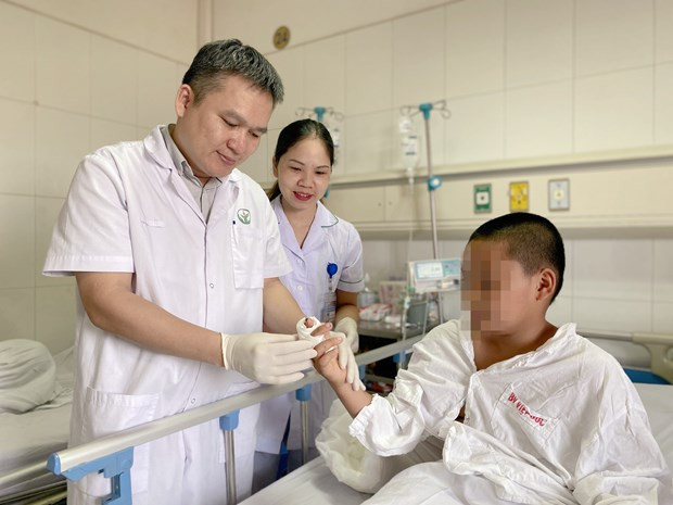 Bác sỹ kiểm tra ngón tay của bệnh nhân sau khi phẫu thuật. Ảnh: PV/Vietnam+