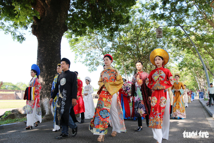 Đoàn áo dài đi ngang trước Kinh thành Huế - Ảnh: NHẬT LINH