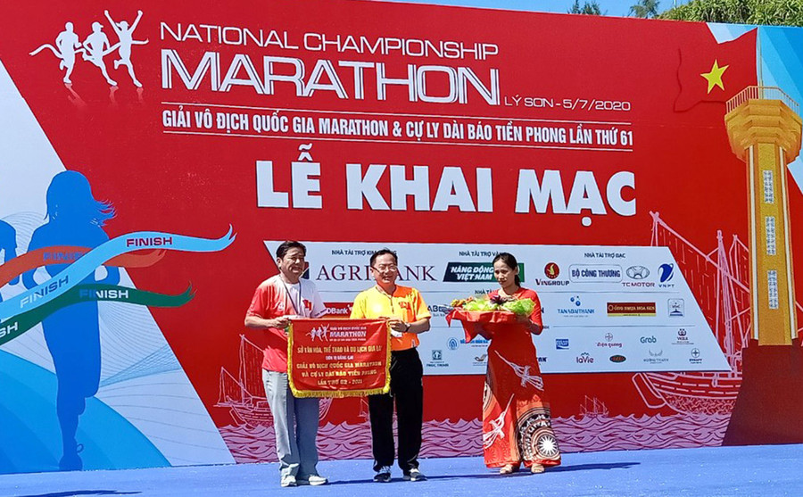 Ông Trần Ngọc Nhung (bên trái)- Giám đốc Sở Văn hóa, Thể thao và Du lịch Gia Lai nhận cờ đơn vị đăng cai Giải Vô địch Quốc gia Marathon và các cự ly dài Báo Tiền Phong lần thứ 62 năm 2021. Ảnh: Minh Vỹ