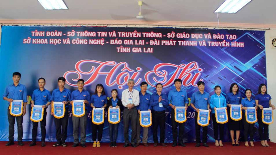 Ban tổ chức trào cờ lưu niệm cho các đơn vị tham gia hội thi. Ảnh: Phan Lài 