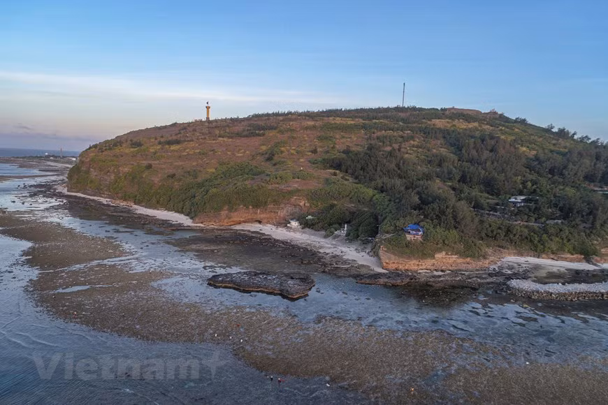 Chùa Hang là một thắng cảnh không thể bỏ qua khi tới Lý Sơn. Địa điểm này cách trung tâm của đảo không xa nhưng đường lên chùa vòng qua eo núi, tạo cảm giác bất ngờ cho du khách khi gặp vẻ đẹp của những thảm cỏ, vạt ngô ven đường, phong cảnh xóm làng, cánh đồng trồng hành tỏi dưới chân núi. Ảnh: Tùng Lâm/Vietnam+