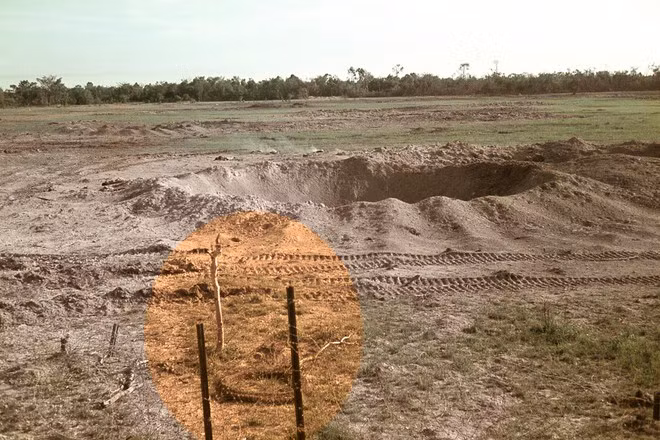 Hố bom trước khi chôn 42 bộ đội VN nằm tại bãi đất trống ẢNH: BRIAN CLEAVER CUNG CẤP