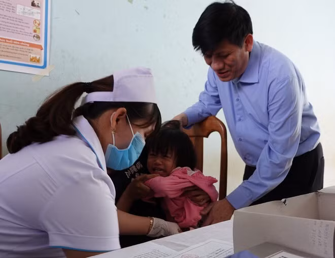Quyền Bộ trưởng Bộ Y tế Nguyễn Thanh Long kiểm tra việc tiêm vắc xin ngay sau lễ phát động. Ảnh: TRẦN HIẾU