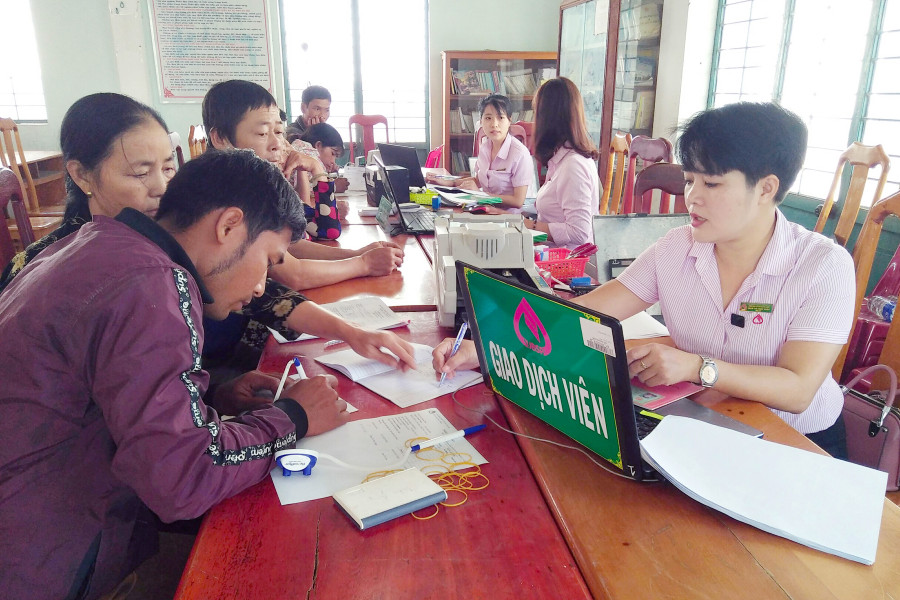 Cán bộ ngân hàng giải ngân vốn tại điểm giao dịch thị trấn Phú Thiện. Ảnh: Phạm Ngọc 
