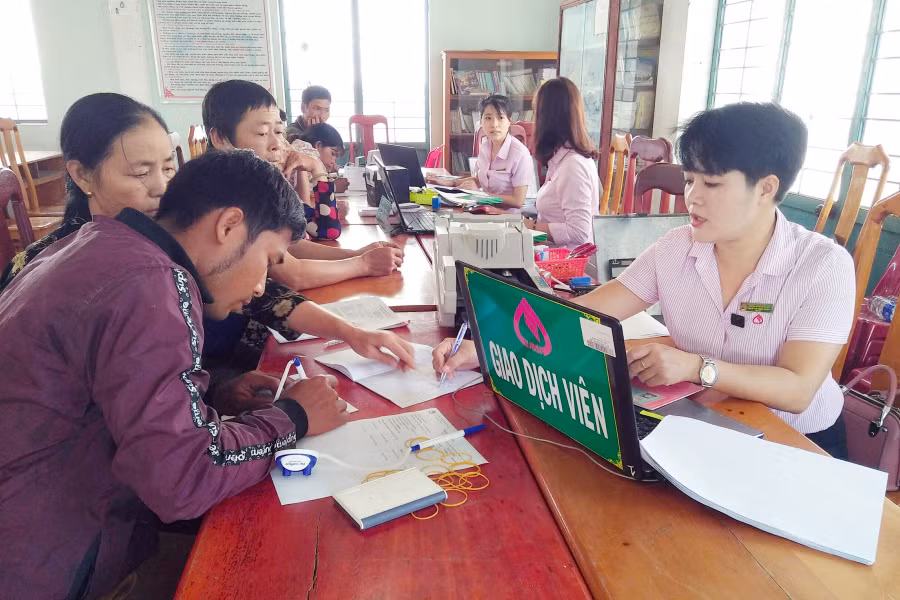 Cán bộ ngân hàng giải ngân vốn tại điểm giao dịch thị trấn Phú Thiện. Ảnh: Phạm Ngọc 