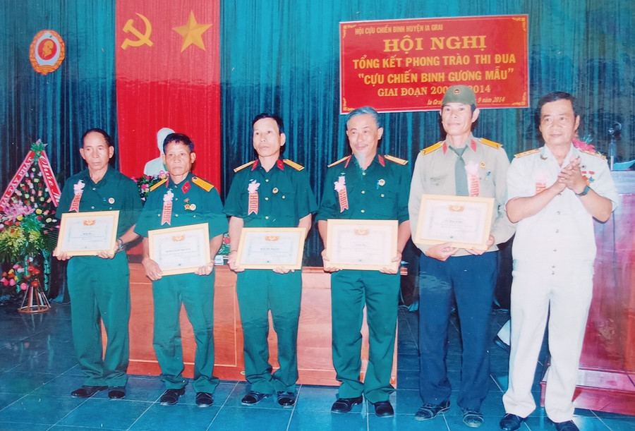 Lãnh đạo Hội CCB huyện Ia Grai (đứng bên phải) trao tặng giấy khen cho các CCB gương mẫu. Ảnh: Hoàng Cư