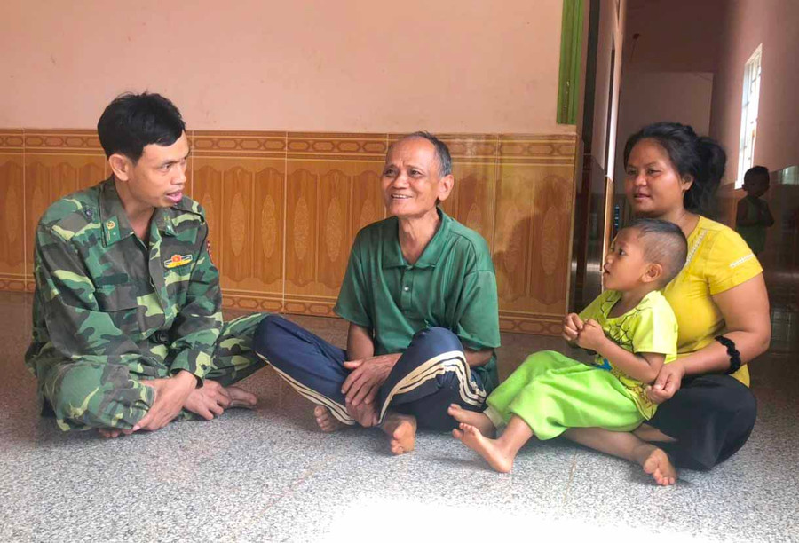 Già làng Rơ Mah Tiến (giữa) trao đổi công việc với Bộ đội Biên phòng. Ảnh: ANH HUY