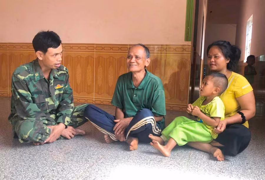 Già làng Rơ Mah Tiến (giữa) trao đổi công việc với Bộ đội Biên phòng. Ảnh: ANH HUY