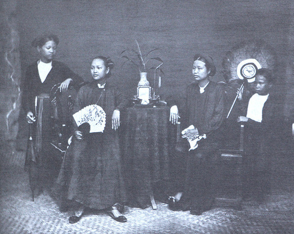 Phụ nữ với áo dài xưa, ảnh chụp năm 1884. Hai người ngồi giữa mặc áo năm thân, hai người hầu mặc áo tứ thân - Ảnh: C. Hocquard