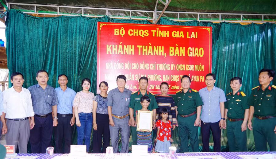 Lãnh đạo, chỉ huy, chính quyền và nhân dân trên địa bàn chụp ảnh lưu niệm cùng gia đình Thượng úy QNCN Ksor Muôn. Ảnh: Huy Bắc 