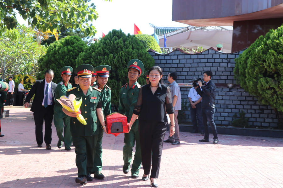 Phó Chủ tịch UBND tỉnh Huỳnh Nữ Thu Hà (đi đầu, bên phải) đưa hài cốt liệt sĩ về nơi an táng. Ảnh: Ngọc Minh