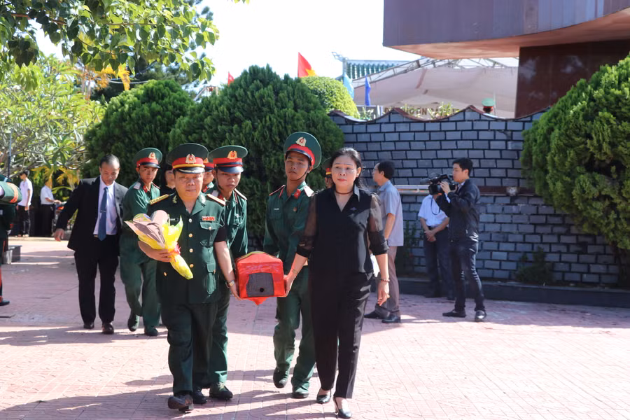 Phó Chủ tịch UBND tỉnh Huỳnh Nữ Thu Hà (đi đầu, bên phải) đưa hài cốt liệt sĩ về nơi an táng. Ảnh: Ngọc Minh