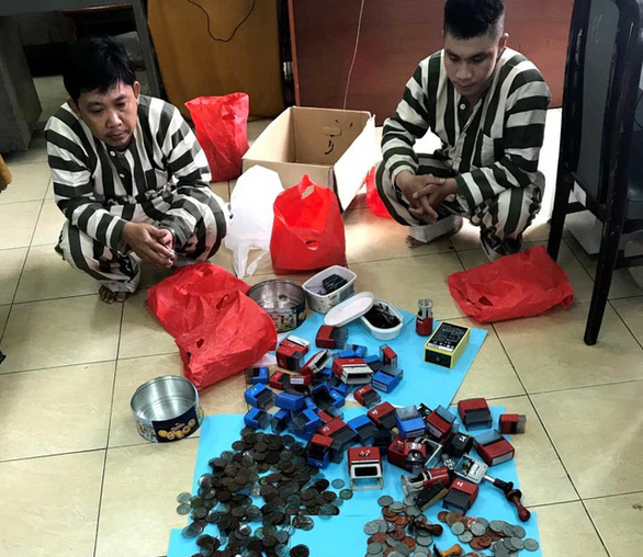 Nghi phạm Hồ Ngọc Quang, Lê Tuấn Anh và số tang vật bị thu giữ - Ảnh: Công an cung cấp