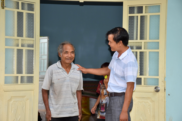 Bệnh binh Đinh Tok (bên trái ảnh-82 tuổi-làng Pốt, xã Song An, thị xã An Khê) phấn khởi trong ngôi nhà mới. Ảnh: Trần Dung 